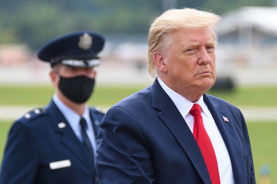 President Donald Trump walks with Air Force Major General John P. Healy in the background wearing a face mask at Dobbins Air Reserve Base. President Donald Trump walks with Air Force Major General John P. Healy in the background wearing a face mask at Dobbins Air Reserve Base.