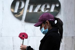 A woman walks by Pfizer's New York headquarters on Nov. 16 as New York City tries to contain a spike in COVID-19 cases. A woman walks by Pfizer's New York headquarters on Nov. 16 as New York City tries to contain a spike in COVID-19 cases.