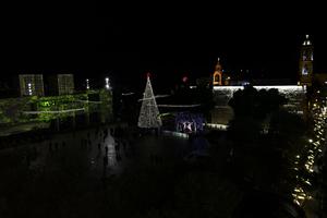 Few people walk around after the lighting of the Christmas tree in Bethlehem in the occupied West Bank, amid the COVID-19 pandemic, on Dec. 5. Bethlehem lit up its Christmas tree, but without the usual crowds, as  coronavirus restrictions put a damper on the start of Christmas festivities in the city of Christ's birth.