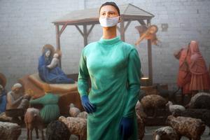 In this Dec. 11 photo, a statue of a health worker stands as part of the Nativity scene at the Basilica of St. Francis in Assisi, Italy. In this Dec. 11 photo, a statue of a health worker stands as part of the Nativity scene at the Basilica of St. Francis in Assisi, Italy.