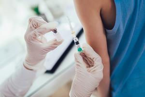 Doctor administers COVID vaccine to a young boy.
