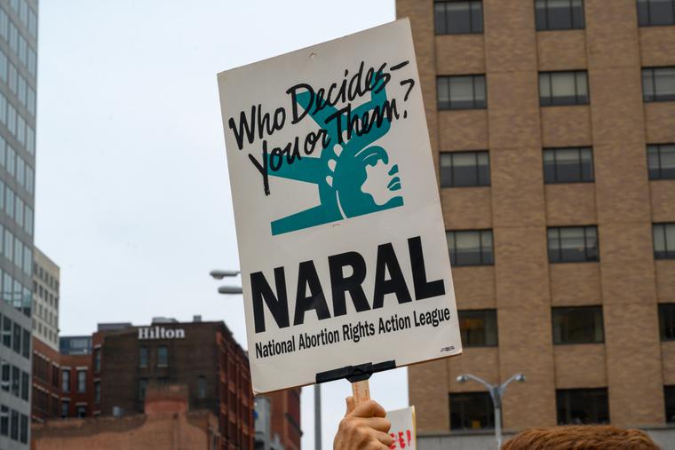 An pro-abortion activist carrying a NARAL (National Abortion Rights Action League) sign at a rally. An pro-abortion activist carrying a NARAL (National Abortion Rights Action League) sign at a rally.