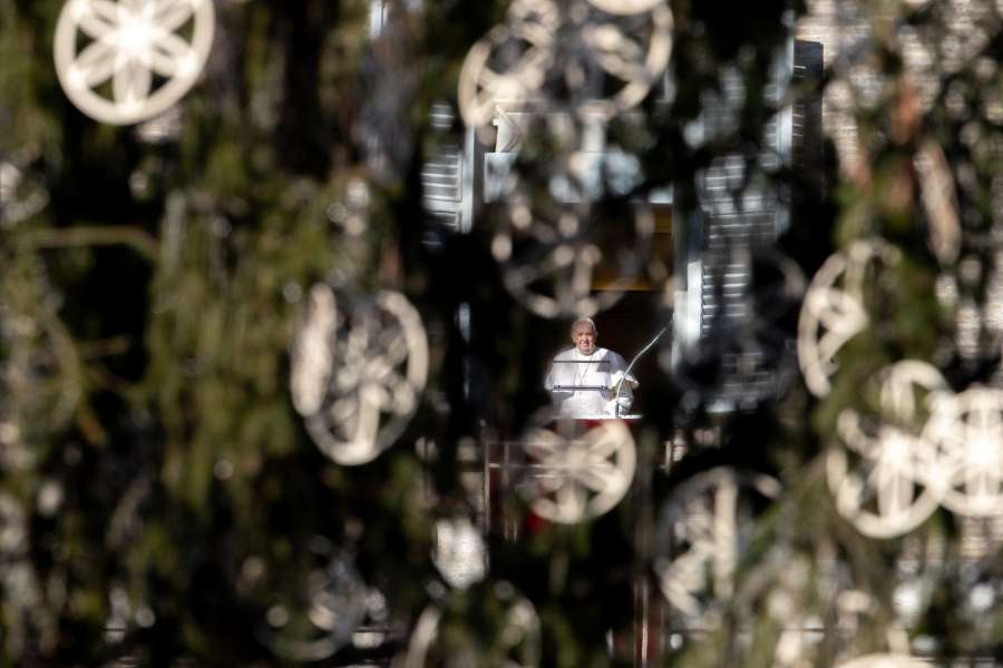 Pope Francis, seen through the Vatican’s Christmas tree, delivers an Angelus address. Pope Francis, seen through the Vatican’s Christmas tree, delivers an Angelus address.