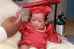 Baby Gloria sits on her mother’s lap after graduating from the NICU. Baby Gloria sits on her mother’s lap after graduating from the NICU.