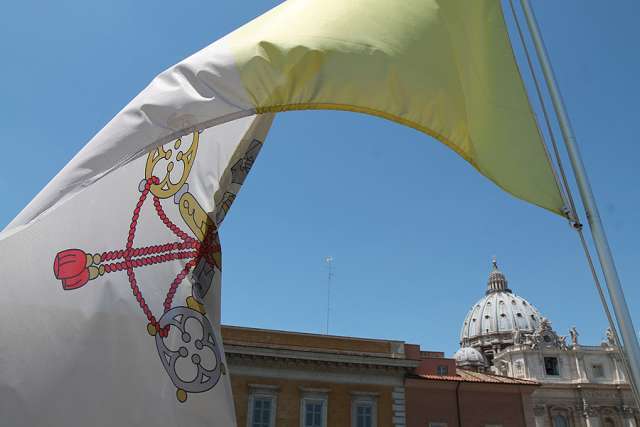 The Vatican flag waves over the dome of St. Peter's Basilica. The Vatican flag waves over the dome of St. Peter's Basilica.