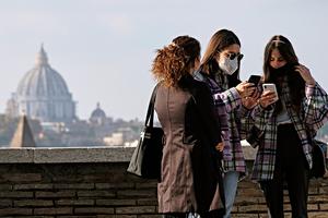 Women wearing protective masks look at their smartphone on a terrace of the Orange Garden (Giardino degli Aranci) on the Aventine Hill overlooking St. Peter's Basilica in Rome on Nov. 11, 2020. Women wearing protective masks look at their smartphone on a terrace of the Orange Garden (Giardino degli Aranci) on the Aventine Hill overlooking St. Peter's Basilica in Rome on Nov. 11, 2020.