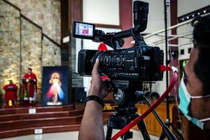A broadcast crew holds a camera at a livestreamed Mass at the Paroki Kristus Raja Baciro Catholic church on April 10, 2020, in Yogyakarta, Indonesia. A broadcast crew holds a camera at a livestreamed Mass at the Paroki Kristus Raja Baciro Catholic church on April 10, 2020, in Yogyakarta, Indonesia.