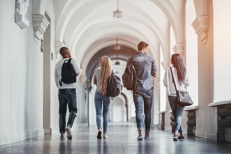 Students walk down a corridor on campus. Students walk down a corridor on campus.