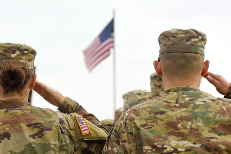 American soldiers salute the American flag. American soldiers salute the American flag.
