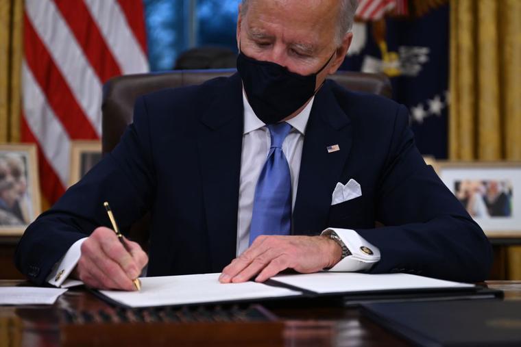 US President Joe Biden signs a series of orders in the Oval Office of the White House in Washington, DC, after being sworn in at the US Capitol on January 20, 2021. US President Joe Biden signs a series of orders in the Oval Office of the White House in Washington, DC, after being sworn in at the US Capitol on January 20, 2021.