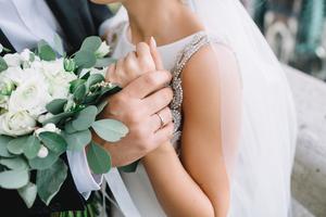 Groom holds bride's wrist on their wedding day. Groom holds bride's wrist on their wedding day.