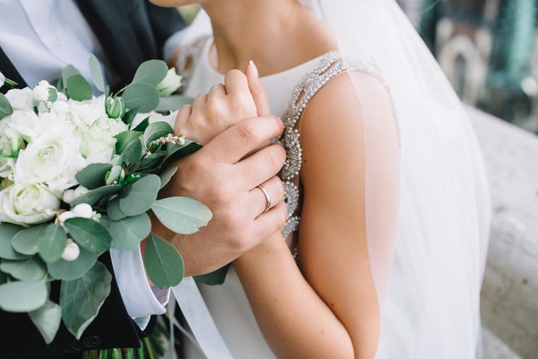 Groom holds bride's wrist on their wedding day. Groom holds bride's wrist on their wedding day.