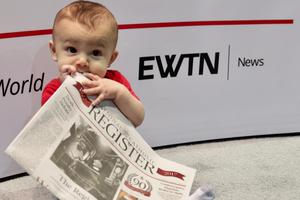 A young baby consuming every page of the National Catholic Register newspaper. A young baby consuming every page of the National Catholic Register newspaper.