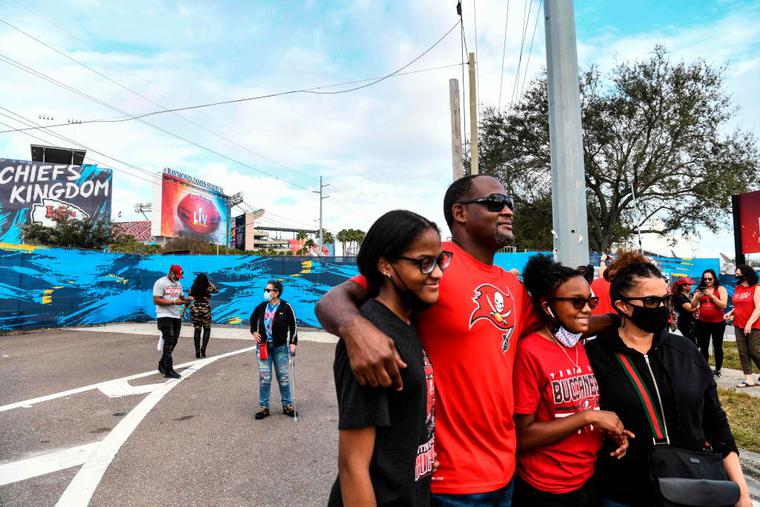 Football fans pose outside of the Raymond James Stadium a day before the Super Bowl match between Kansas City Chiefs and Tampa Bay Buccaneers in Tampa, Florida on February 6, 2021. Football fans pose outside of the Raymond James Stadium a day before the Super Bowl match between Kansas City Chiefs and Tampa Bay Buccaneers in Tampa, Florida on February 6, 2021.