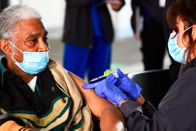 Elton Jackson, 80, looks on as he receives his COVID-19 vaccine, administered by Kathryne Acuna, director of Ambulatory Clinical Services at Kaiser Permanente, on Feb. 5, the opening day of a large-scale vaccination site at a parking structure at Cal Poly Pomona University in Pomona, California. The elderly are among those given priority during the vaccine rollout across the country. Elton Jackson, 80, looks on as he receives his COVID-19 vaccine, administered by Kathryne Acuna, director of Ambulatory Clinical Services at Kaiser Permanente, on Feb. 5, the opening day of a large-scale vaccination site at a parking structure at Cal Poly Pomona University in Pomona, California. The elderly are among those given priority during the vaccine rollout across the country.