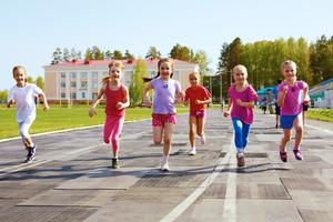Young girls run outside on the track. Young girls run outside on the track.