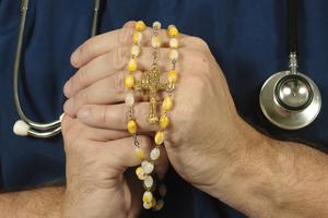 A Catholic doctor folding hands with his Rosary. A Catholic doctor folding hands with his Rosary.