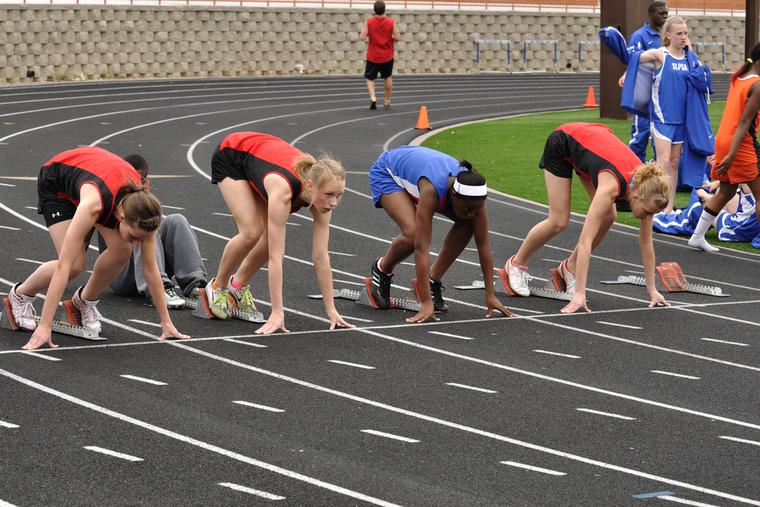 Teenage girls set to race in a track meet. Teenage girls set to race in a track meet.