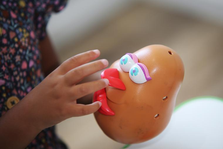 A young girl pieces together Hasbro's Mrs. Potato Head. A young girl pieces together Hasbro's Mrs. Potato Head.