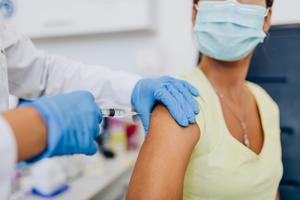 A woman receiving her first COVID-19 vaccine shot. A woman receiving her first COVID-19 vaccine shot.