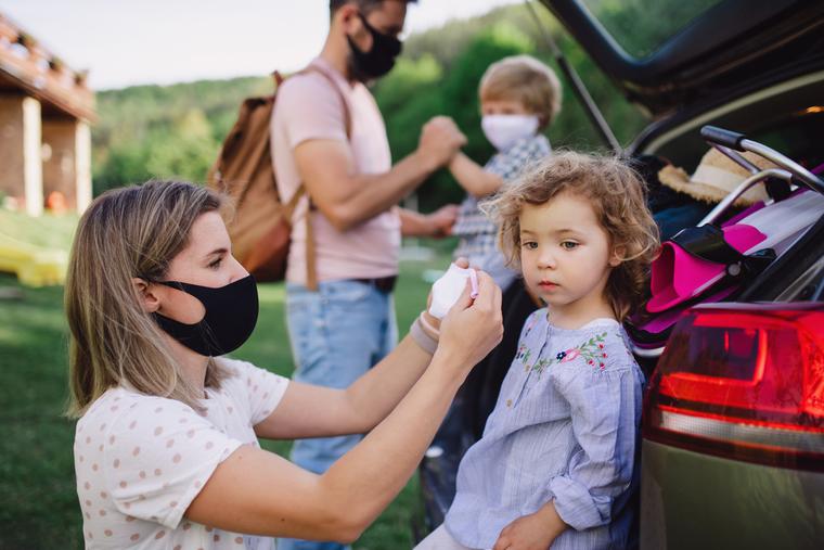 A family prepares to go indoors amid the COVID pandemic, putting masks on their two small children. A family prepares to go indoors amid the COVID pandemic, putting masks on their two small children.