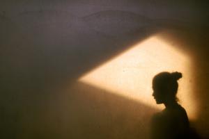 A woman sits alone in a dark room. A woman sits alone in a dark room.