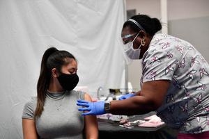 A nurse administers a dose of the Moderna Covid-19 vaccine at a clinic for Catholic school education workers including elementary school teachers and staff at a vaccination site at Loyola Marymount University (LMU) on March 8, 2021 in Los Angeles, Calif.