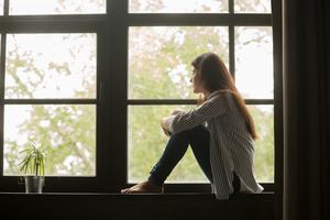 A woman sits in contemplation after learning she miscarried her child. A woman sits in contemplation after learning she miscarried her child.