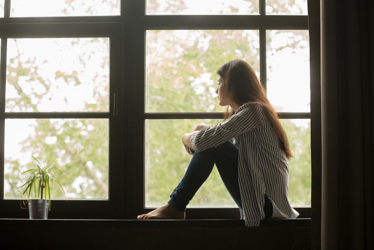 A woman sits in contemplation after learning she miscarried her child. A woman sits in contemplation after learning she miscarried her child.
