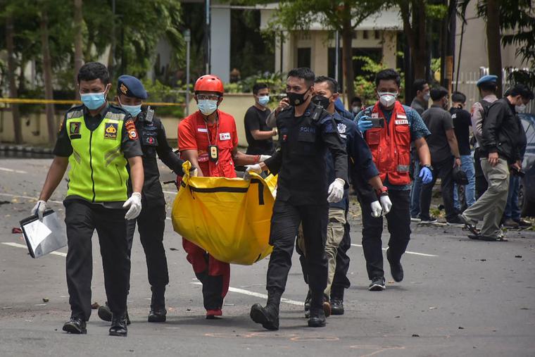 Indonesian police carry a bag with the remains of a suspected suicide bomber after an explosion outside a church in Makassar on March 28, 2021. Indonesian police carry a bag with the remains of a suspected suicide bomber after an explosion outside a church in Makassar on March 28, 2021.