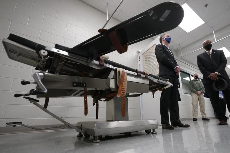 Gov. Ralph Northam, left, stands near a gurney with Greensville Correctional Center warden Larry Edmonds, right, at the Greensville Correctional Center prior to signing a bill abolishing the state's death penalty in Jarratt, Va., Wednesday, March 24, 2021. Gov. Ralph Northam, left, stands near a gurney with Greensville Correctional Center warden Larry Edmonds, right, at the Greensville Correctional Center prior to signing a bill abolishing the state's death penalty in Jarratt, Va., Wednesday, March 24, 2021.