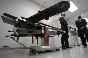 Gov. Ralph Northam, left, stands near a gurney with Greensville Correctional Center warden Larry Edmonds, right, at the Greensville Correctional Center prior to signing a bill abolishing the state's death penalty in Jarratt, Va., Wednesday, March 24, 2021. Gov. Ralph Northam, left, stands near a gurney with Greensville Correctional Center warden Larry Edmonds, right, at the Greensville Correctional Center prior to signing a bill abolishing the state's death penalty in Jarratt, Va., Wednesday, March 24, 2021.