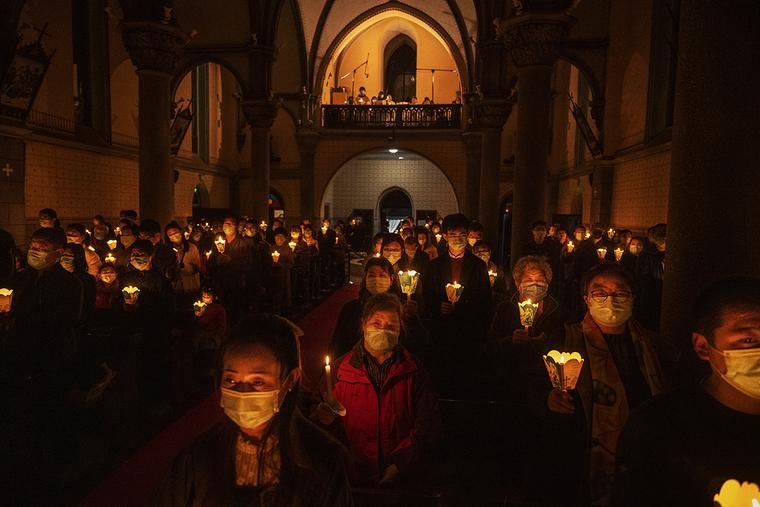 Chinese Catholics hold candles during the Easter Vigil Mass at a church in Beijing on April 3. Chinese Catholics hold candles during the Easter Vigil Mass at a church in Beijing on April 3.