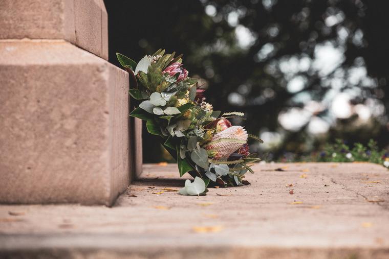 Flowers and wreath laid beside a headstone at a cemetery. Flowers and wreath laid beside a headstone at a cemetery.