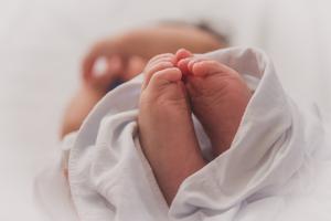 A newborn sleeps swaddled in a blanket. A newborn sleeps swaddled in a blanket.