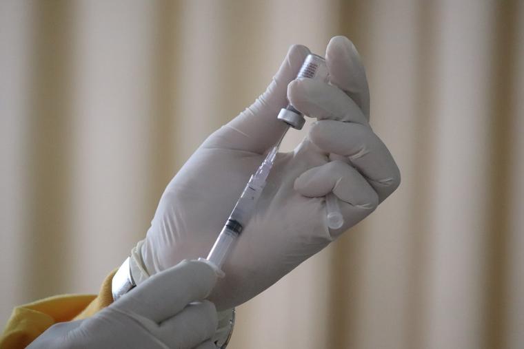 A doctor prepares to administer a vaccine. A doctor prepares to administer a vaccine.