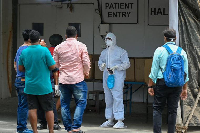 A health worker wearing Personal Protective Equipment (PPE) gear speaks with family members outside a recovery center to treat COVID-19 patients, in Mumbai, India, on April 22. Coronavirus infections are currently spiking there. A health worker wearing Personal Protective Equipment (PPE) gear speaks with family members outside a recovery center to treat COVID-19 patients, in Mumbai, India, on April 22. Coronavirus infections are currently spiking there.