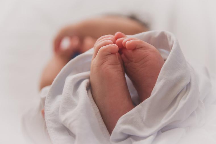 A newborn baby swaddled in a blanket. A newborn baby swaddled in a blanket.