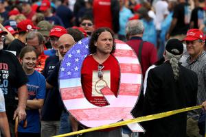 David Reinert holds a large "Q" sign while waiting in line at a rally August 2, 2018 at the Mohegan Sun Arena at Casey Plaza in Wilkes Barre, Pennsylvania. David Reinert holds a large "Q" sign while waiting in line at a rally August 2, 2018 at the Mohegan Sun Arena at Casey Plaza in Wilkes Barre, Pennsylvania.