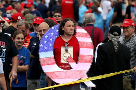 David Reinert holds a large "Q" sign while waiting in line at a rally August 2, 2018 at the Mohegan Sun Arena at Casey Plaza in Wilkes Barre, Pennsylvania. David Reinert holds a large "Q" sign while waiting in line at a rally August 2, 2018 at the Mohegan Sun Arena at Casey Plaza in Wilkes Barre, Pennsylvania.