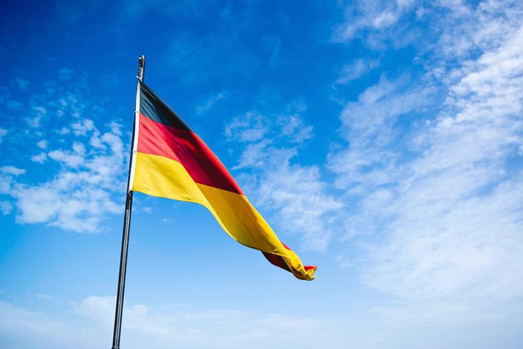 Flag of Germany waves in the breeze on a clear day in Berlin. Flag of Germany waves in the breeze on a clear day in Berlin.