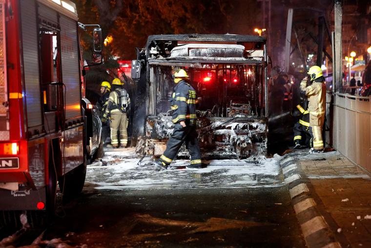 Israeli firefighters check out a burnt bus in the Israeli town of Holon near Tel Aviv, on May 11, 2021, after rockets are launched towards Israel from the Gaza Strip controlled by the Palestinian Hamas movement. Israeli firefighters check out a burnt bus in the Israeli town of Holon near Tel Aviv, on May 11, 2021, after rockets are launched towards Israel from the Gaza Strip controlled by the Palestinian Hamas movement.