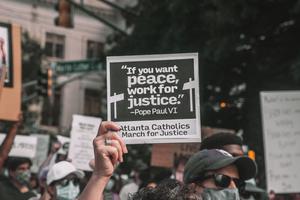 A participant holds up a sign with a quote from Pope St. Paul VI at a June 2020 rally in Atlanta. A participant holds up a sign with a quote from Pope St. Paul VI at a June 2020 rally in Atlanta.