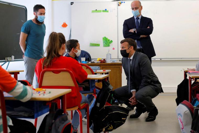 French President Emmanuel Macron (C) and French Education, Youth and Sports Minister Jean-Michel Blanquer (C,R) speak with pupils during a visit at a primary school in Melun, on April 26, 2021. French President Emmanuel Macron (C) and French Education, Youth and Sports Minister Jean-Michel Blanquer (C,R) speak with pupils during a visit at a primary school in Melun, on April 26, 2021.
