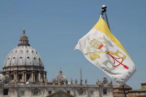 A Vatican City flag flies in view of St. Peter’s Basilica in Rome. A Vatican City flag flies in view of St. Peter’s Basilica in Rome.