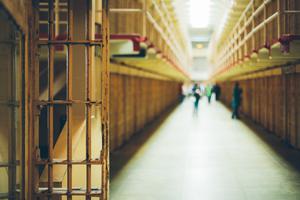 A long corridor of cell blocks inside a federal prison. A long corridor of cell blocks inside a federal prison.