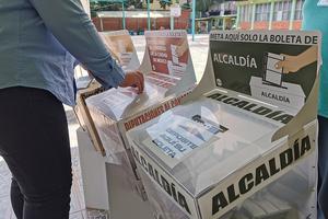 A woman inserting her vote into a ballot box, Mexico City, 6 June 2021. A woman inserting her vote into a ballot box, Mexico City, 6 June 2021.