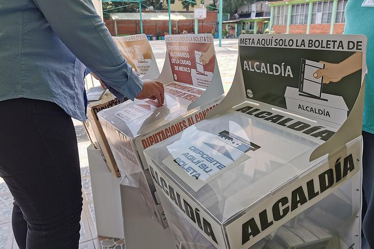 A woman inserting her vote into a ballot box, Mexico City, 6 June 2021. A woman inserting her vote into a ballot box, Mexico City, 6 June 2021.