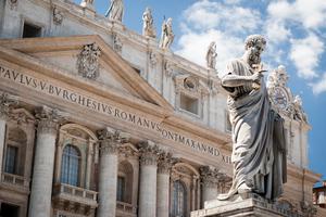 Statue of St. Peter with the facade of St. Peter's Basilica in the background. Statue of St. Peter with the facade of St. Peter's Basilica in the background.