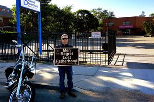 A pro-life activist carries a sign at a Planned Parenthood facility in New York. A pro-life activist carries a sign at a Planned Parenthood facility in New York.